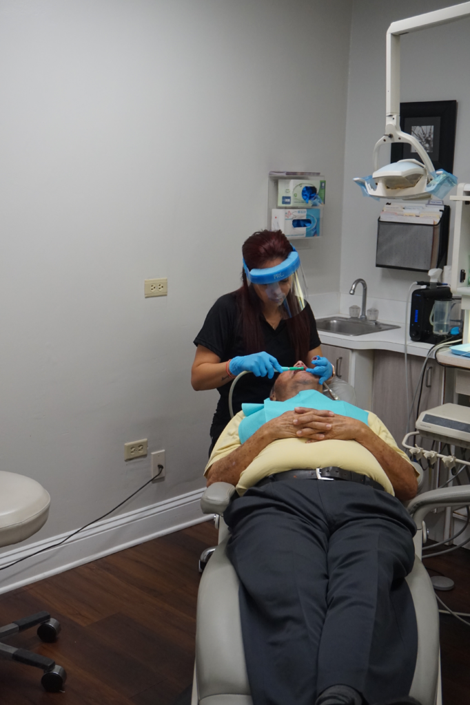 A Dentist in Jacksonville, FL, Treating a Patient Lying on Their Back