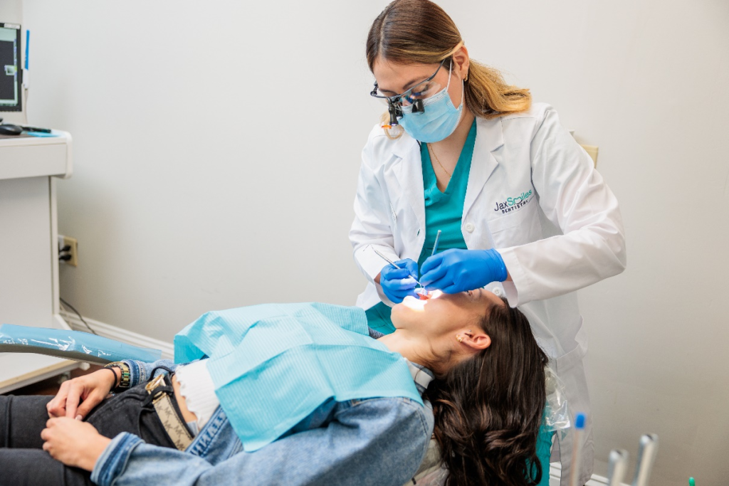 Dr. Elssy Lopez performing a dental checkup before dental implant service at Jax Smiles Dentistry