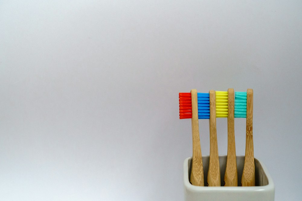 Four wooden toothbrushes with colored bristles 